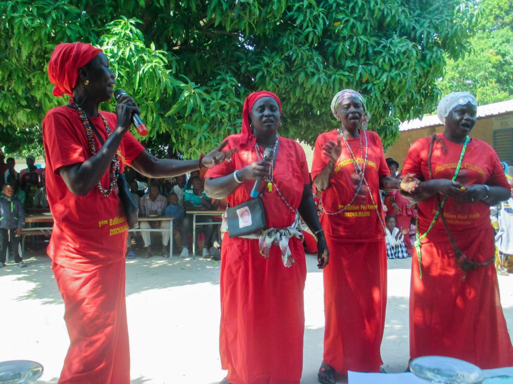 Une groupe de femmes vêtue en rouge chante.